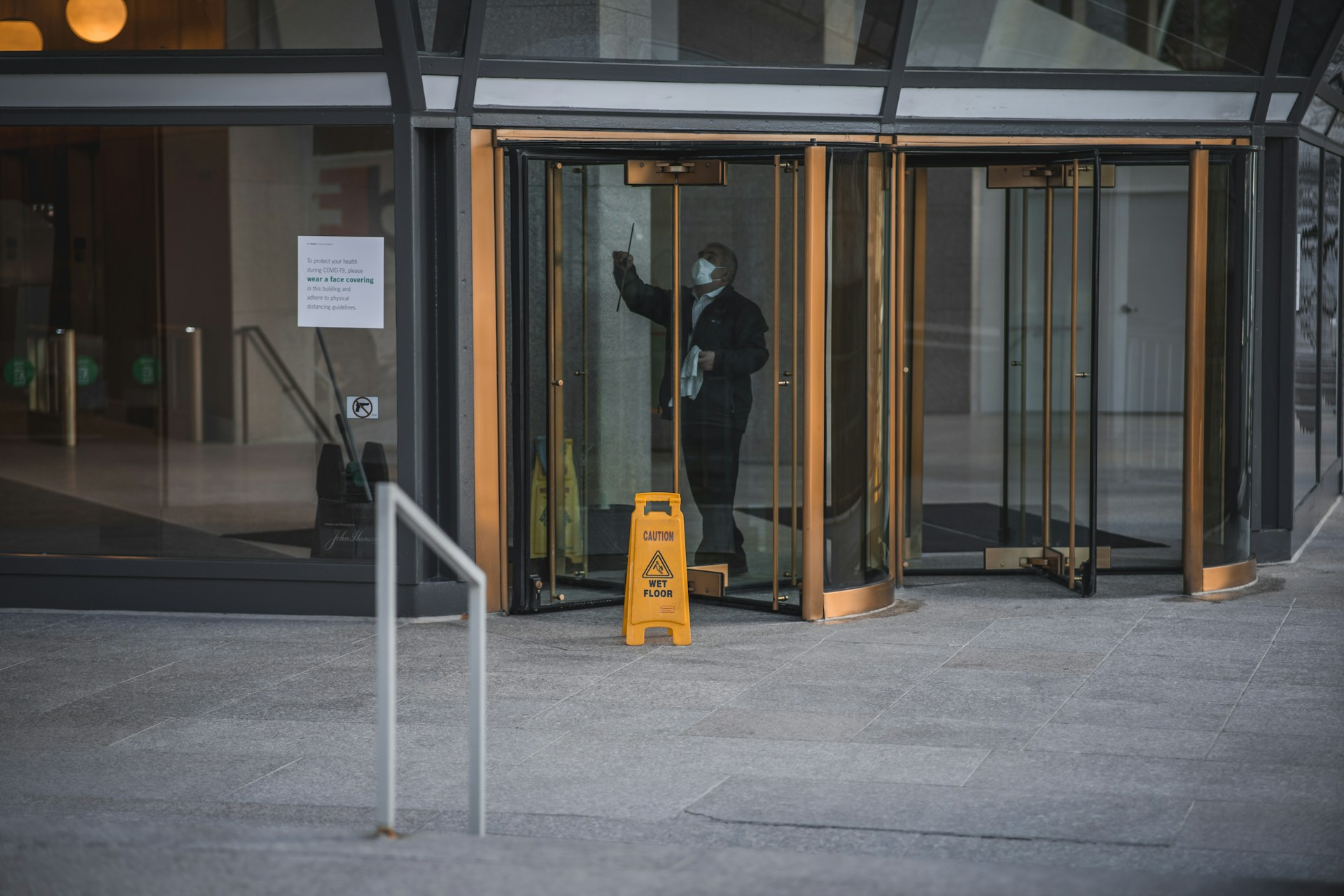 cleaner-cleaning-window-of-office-building-entrance.jpg